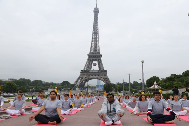 Yoga enthusiasts in Paris with Eiffel Tower in the background